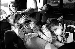  ?? JOHN LOCHER/AP ?? Havyn Cargill-Morris, from left, Dakota Keltner, Atryna Sweet and Timothy Keltner rest in a truck at a makeshift encampment in Chico, Calif. They fled Magalia with their families.