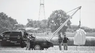  ?? Associated Press file photo ?? A crew hoists a bag holding the remains of a hot air balloon that crashed in 2016 near Lockhart. Sixteen people were killed in the incident, including the pilot.