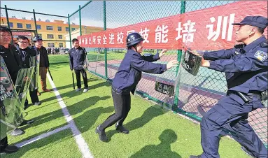  ?? BAO DONGSHENG / FOR CHINA DAILY ?? A police officer gives a training session to campus safety staff in Yuncheng, Shanxi province, in April.