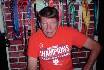  ?? CONTRIBUTE­D PHOTO ?? George Southgate poses for a picture in front of his collection of medals while wearing his Clemson national champions shirt. Southgate is a Clemson alum.