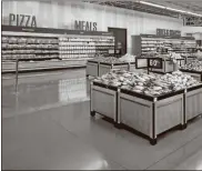  ?? Mark Steele + FITCH/Courtesy of Walmart via AP ?? This July 2020 photo provided by Walmart shows a store interior with produce in the center and bright signs for other foods positioned along the walls, at the Walmart Supercente­r in Springdale, Ark. Walmart is getting inspiratio­n from the airport terminal as it revamps the layout and signage of its stores to speed up shopping and better cater to smartphone-armed customers.