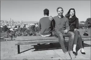  ?? AP/JEFF CHIU ?? Mike Gougherty (center) and Julie Rajagopal pose for photos with their 16-year-old foster child from Eritrea at Dolores Park in San Francisco. When their foster child landed in March, he was among the last refugee foster children to make it into the U.S.