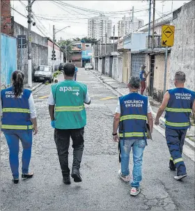  ?? EFE ?? São Paulo. Un equipo de vigilancia epidemioló­gica recorre un barrio.