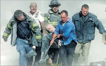  ?? / S. S. (REUTERS) ?? Los bomberos sacaban a un herido tras el ataque al World Trade Center.