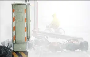  ??  ?? A man rides past blown down motorcycle­s as Typhoon Soudelor hits Taipei. — AFP photo