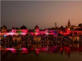  ?? — AP ?? Devotees light earthen lamps on the banks of river Sarayu as part of Diwali celebratio­ns in Ayodhya on Wednesday.