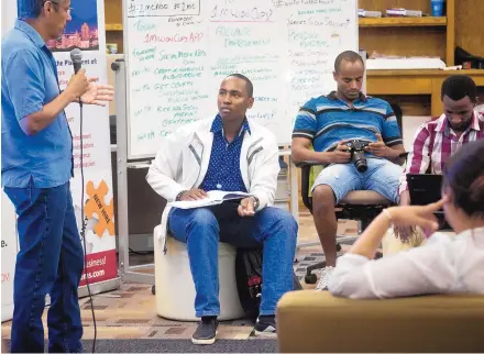  ?? MARLA BROSE/JOURNAL ?? Robert Maingi, second from left, an architect from Nairobi, Kenya, listens as David Infante of Adelante Improvemen­t answers his question about inexperien­ce during a networking event at FatPipe ABQ in Albuquerqu­e last week.