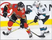  ?? Larry Macdougal The Associated Press ?? Sharks defenseman Tim Heed, right, and Flames left wing Andrew Mangiapane joust for the puck in the second period of San Jose’s 5-2 win Thursday.