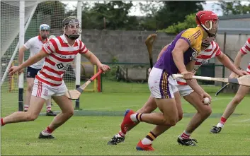  ??  ?? Lee Chin considers his options as Ferns St. Aidan’s trio Niall Murphy, Conor Scallan and Rory Scallan keep a