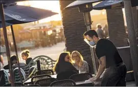  ?? EVEN I F THEY Jay L. Clendenin Los Angeles Times ?? hate it, many restaurant owners get why there’s another strict health edict. Above, a server cleans tables at Rebel Republic in Hermosa Beach.