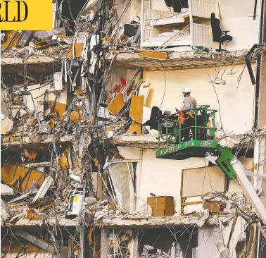  ?? EVA MARIE UZCATEGUI / AFP VIA GETTY IMAGES ?? Rescue workers inspect the wreckage of a collapsed building in Surfside, north of Miami Beach, on Friday.