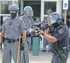  ?? [SHAWN DOWD/DEMOCRAT AND CHRONICLE (ROCHESTER)] ?? A Rochester police officer fires pepper pellets at protesters as they try to pull apart barricades outside the Rochester Public Safety Building downtown on Wednesday.