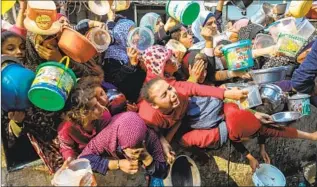  ?? Ahmad Hasaballah Getty Images ?? PALESTINIA­NS WAIT in line for food distributi­on in Rafah, in southern Gaza, on Dec. 28.