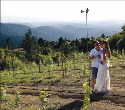  ?? JIM GENSHEIMER — STAFF PHOTOGRAPH­ER ?? Britney Reeves and Matt Miller, both of Los Gatos, roam the vineyards at Loma Prieta Winery in this file photo. Loma Prieta is among the local wineries offering Valentine’s Day deals for oenophiles.