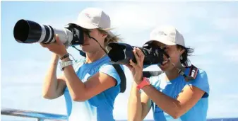  ??  ?? Rebecca Wellard (above, at left) and Zoe Gillam focus their lenses on orca fins. Rebecca looks at the dorsal fins, eye patches and saddle patches to identify each animal. Data is used to study group structure and size, as well as migration patterns;...