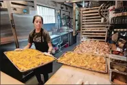 ?? ?? Below, Sandra Castillo removes pretzels from the oven at Von Elrod’s.