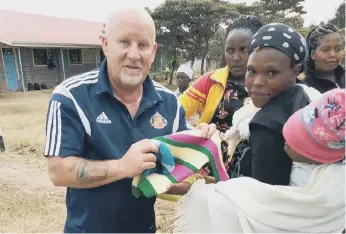  ?? ?? Gary hands out donations of clothing in Keroche.