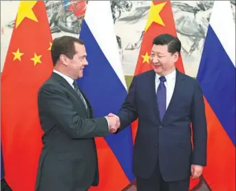  ?? XIE HUANCHI / XINHUA ?? President Xi Jinping greets visiting Russian Prime Minister Dmitry Medvedev at the Diaoyutai State Guesthouse in Beijing on Wednesday. Medvedev is on a three-day official visit.