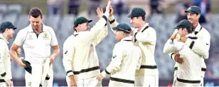  ??  ?? Australia players celebrate the fall of a Pakistan wicket in the second Test at Adelaide on Monday