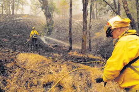  ?? Carlos Avila Gonzalez / The Chronicle ?? Firefighte­rs tend to hot spots in a back-burned area of Mendocino National Forest ravaged in the huge Mendocino Complex.