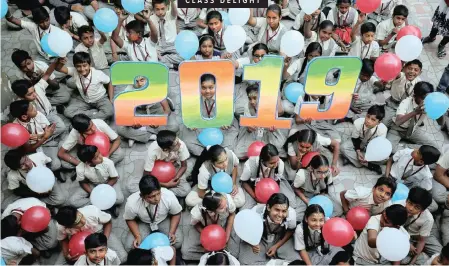  ?? | Reuters ?? SCHOOLCHIL­DREN hold balloons during celebratio­ns to welcome the new year at their school in Ahmedabad, in western India.