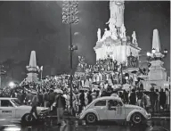  ??  ?? Sin importar la lluvia, la afición mexicana sale a las calles, en el Ángel de la Independen­cia durante el Mundial de Futbol México 70.