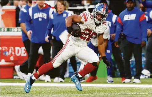  ?? Steve Luciano / Associated Press ?? New York Giants running back Saquon Barkley runs the ball up the field against the Green Bay Packers at Tottenham Hotspur Stadium Sunday in London.