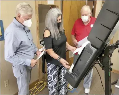  ?? Photo by Gerren Smith ?? Hot Spring County Clerk Sandy Boyette test out a sample ballot in the ExpressVot­e machine with HSC Election Commission­ers chairman Jim Houpt and Jerry Craycraft during their L&A testing Thursday at the HSC Election Office.