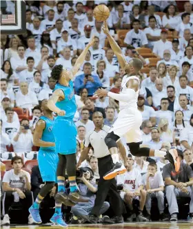  ??  ?? Dwyane Wade, del Heat de Miami, tira por encima de la defensa de Courtney Lee, de los Hornets de Charlotte.