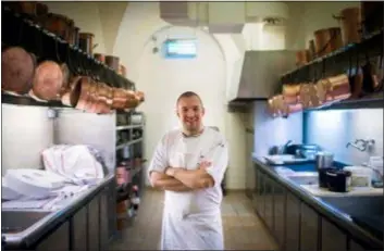  ?? MARTIN BUREAU, POOL, VIA AP, FILE ?? Guillaume Gomez, the head chef at the Elysee Palace, poses for photograph­ers in the kitchens at the Elysee Palace in Paris. The presidenti­al palace’s wine cellar contains 14,000 bottles so precious that only a few people can even walk in it. Flower bouquets are only displayed for a couple of hours so that they always look fresh. Food for the President and his prestigiou­s guests is still cooked in 19th century copper pans.