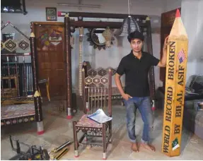  ??  ?? In this photograph taken on October 4, artist Bilal Asif poses for a photograph with his pencils artwork at his studio in Karachi.