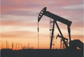  ??  ?? An oil pumpjack draws from the Permian Basin in Texas. Gas prices have sunk to a national average of $1.86 a gallon, the lowest since 2009. Spencer Platt, Getty Images