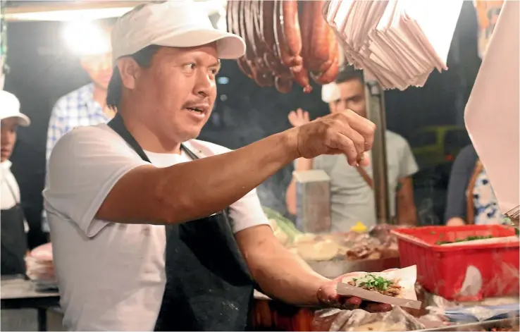  ?? BRETT ATKINSON ?? During the day, El Vilsito in Mexico City’s Narvarte Poniente neighbourh­ood is a good place to get your car repaired but, after dark, the garage becomes one of the city’s best spots for tacos al pastor.