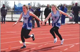  ?? Alex Eller ?? Bryn Schwarz and Halie Recoy of South Loup prepare for hand off during the 4x100 Meter Relay at the UNK Invite. The Bobcats ended up getting second in the relay with a time of 56.08.