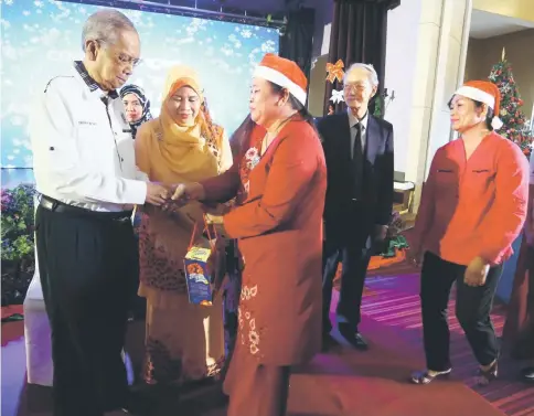  ??  ?? Recipients receiving their presents from Adenan and his wife.