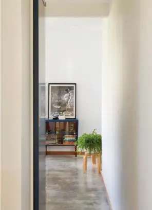  ??  ?? Above The black door opens to the main bedroom. Concrete floors throughout the home are heated.
Right Yellow is used sparingly to break up the white interiors.