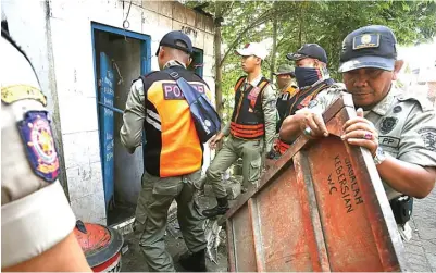  ?? AHMAD KHUSAINI/JAWA POS ?? GARA-GARA LOMBA: Petugas satpol PP membongkar toilet umum yang didirikan warga di bantaran sungai di sepanjang Karang Tembok kemarin (7/8).