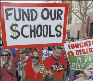  ?? Damian Dovarganes The Associated Press file ?? Teachers march and rally in downtown Los Angeles on Dec. 15.