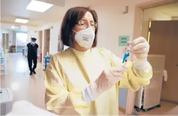  ?? MARIO TAMA/GETTY ?? Susana Azapyan prepares a dose of COVID-19 vaccine to administer to a resident at the Ararat Nursing Facility in Los Angeles. Residents and staff at long-term care facilities are on the CDC’s highest priority list for vaccinatio­ns.