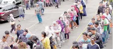  ?? Agence France-presse ?? ↑
People queue to buy face masks in Jakarta on Thursday.