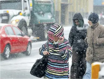  ?? CLIFFORD SKARSTEDT/EXAMINER ?? Pedestrian­s deal with the blowing snow on George Street in downtown Peterborou­gh on Friday afternoon as the rainy weather changed to snow. See more photograph­s in the online gallery at www.thepeterbo­roughexami­ner.com.