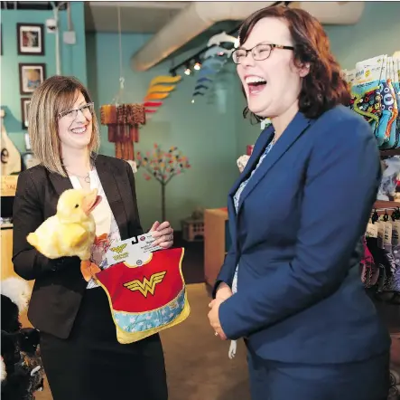  ?? LEAH HENNEL ?? Service Alberta Minister Stephanie McLean, left, who gave birth last year, and Justice Minister Kathleen Ganley, who is expecting, check out baby toys after the announceme­nt of the top Alberta baby names of 2016 at Babes in Arms boutique in Calgary on...