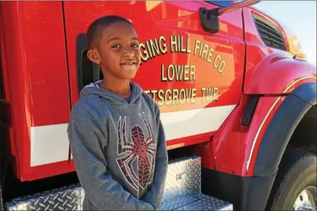  ?? EVAN BRANDT — DIGITAL FIRST MEDIA ?? Just days after he alerted his family to a fire in their Rolling Hills home, Ringing Rocks Elementary School second grader Nahzir Grant, 8, got to enjoy a visit from the Ringing Hill Fire Company for Fire Prevention Week.