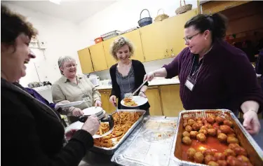  ?? JULIE JOCSAK TORSTAR ?? Volunteers serve dinner as part of the Out of The Cold Program in this file photo.