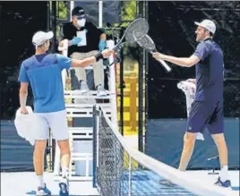  ?? AFP ?? n
Poland’s Hubert Hurkacz (left) and Reilly Opelka of the US tap racquets after their match during the Pro Match Series in Florida. Players are banned from shaking hands under new safety guidelines.