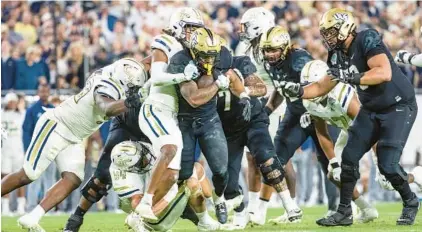  ?? WILLIE J. ALLEN JR./ORLANDO SENTINEL ?? UCF running back RJ Harvey (7) drives his legs to gain a few extra yards against Georgia Tech during the second half of the Union Home Mortgage Gasparilla Bowl on Dec. 22 at Raymond James Stadium in Tampa.