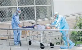  ?? BHARAT BHUSHAN /HT ?? ■ Health workers in protective suits help transfer suspected corona positive patient at Government Rajindra Hospital in Patiala on Saturday.