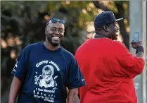  ?? GREG LOVETT / THE PALM BEACH POST ?? Maurice Hayes (left) smiles next to Javaris Russ as they watch basketball at Sara Sims Park. Hayes came up with the idea and Russ helped organize “Peace in the Hood” to bring the community together in light of recent gun violence that ripped apart two...