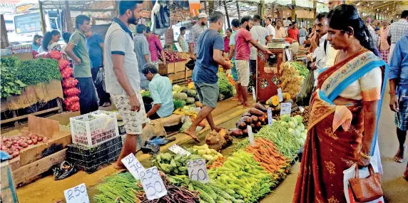  ??  ?? Pettah market: Consumers look despondent­ly at the price of vegetables. Pix by Priyantha Wickramaar­achchi