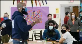  ?? AP PHOTO/KATHY WILLENS, FILE ?? Students, teachers, administra­tors and counselors listen Oct. 29, 2020, as principal Malik Lewis, foreground, second from left, teaches them a history lesson at West Brooklyn Community High School in New York.